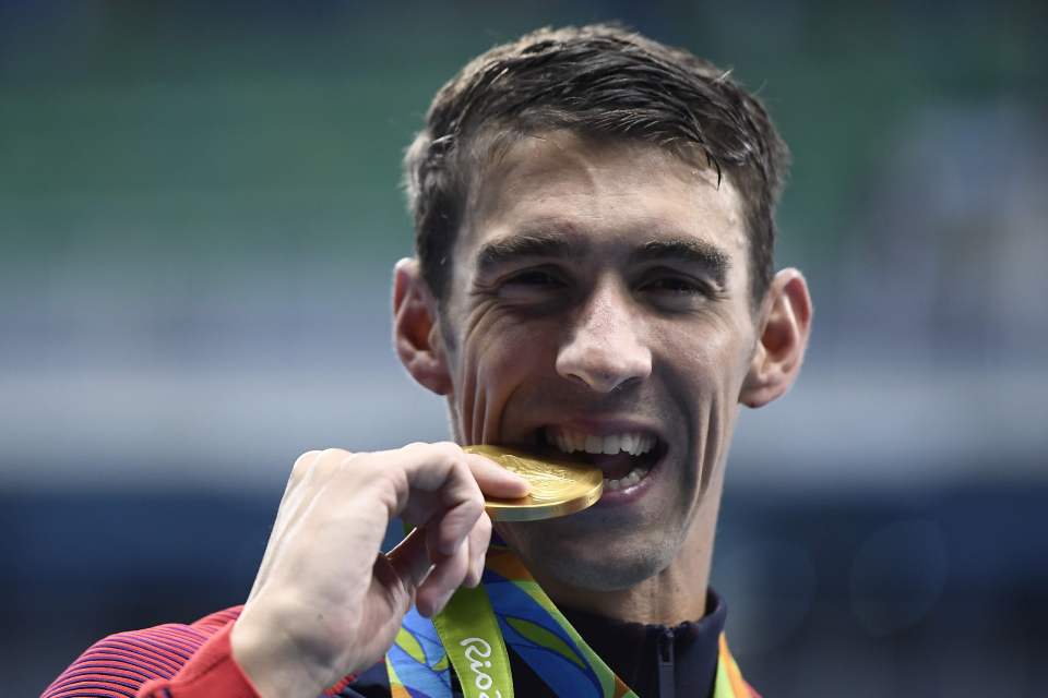USA's Michael Phelps kisses his gold med