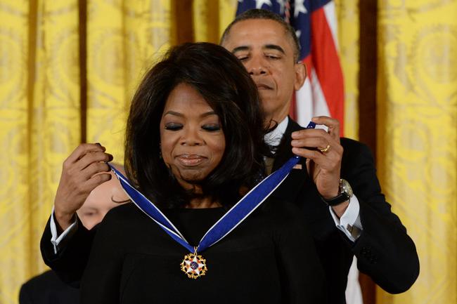 epa03958505 US President Barack Obama (back) awards the Presidential Medal of Freedom to Oprah Winfrey (front), in the East Room of the White House in Washington DC, USA, 20 November 2013. The Medal of Freedom is the highest civilian honor presented to individuals who have made especially meritorious contributions to the security or national interests of the US, to world peace, or to cultural or other significant public or private endeavors.  EPA/MICHAEL REYNOLDS